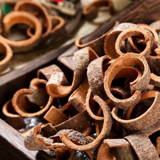 Curled cassia bark pieces packed in a wooden container