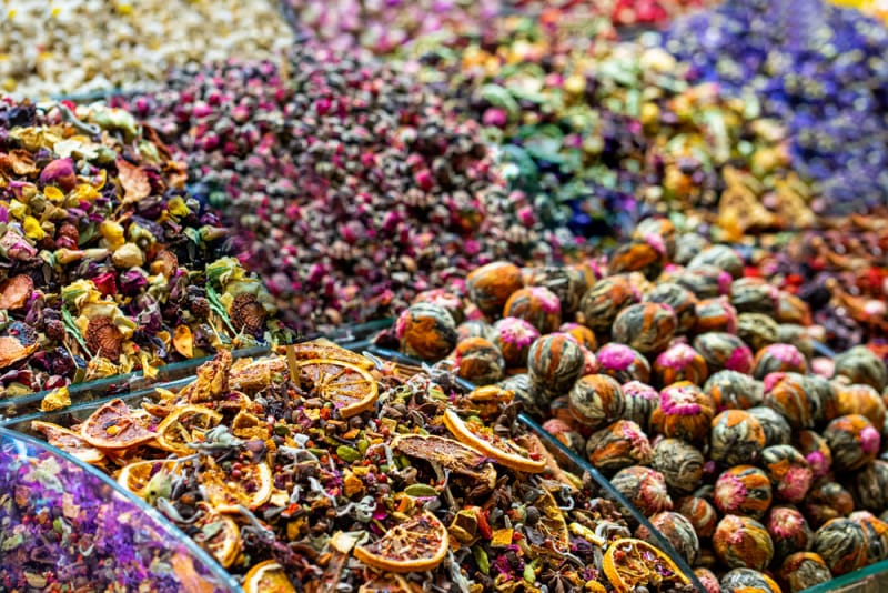 Colorful dried fruit and herbal tea displays at a spice market stall