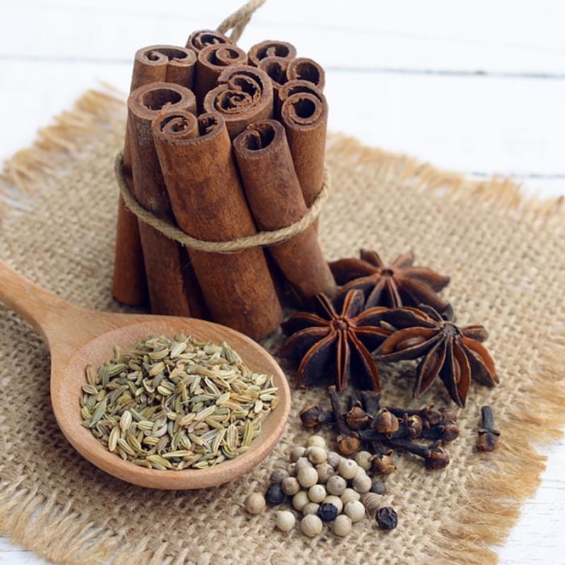 Five spice ingredients with star anise, cinnamon, cloves, pepper and fennel on burlap